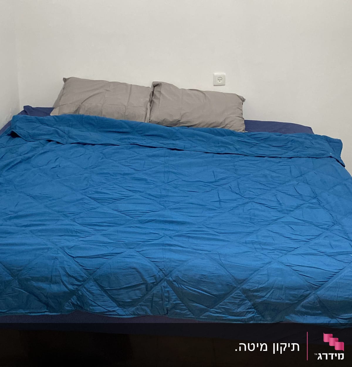 חדר שינה עם מיטה זוגית, כריות ושמיכה כחולה